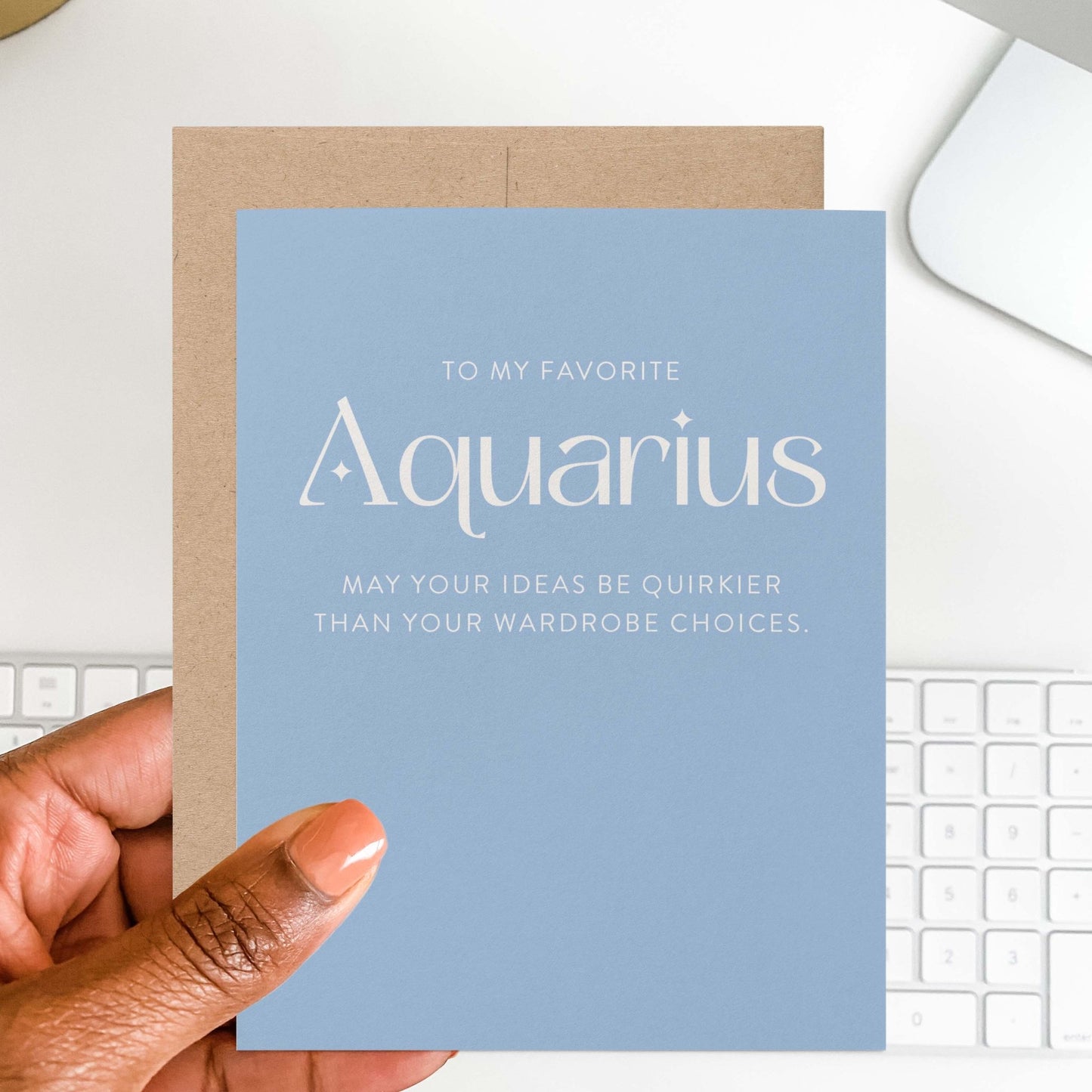 Hand holding modern Aquarius zodiac birthday card in blue