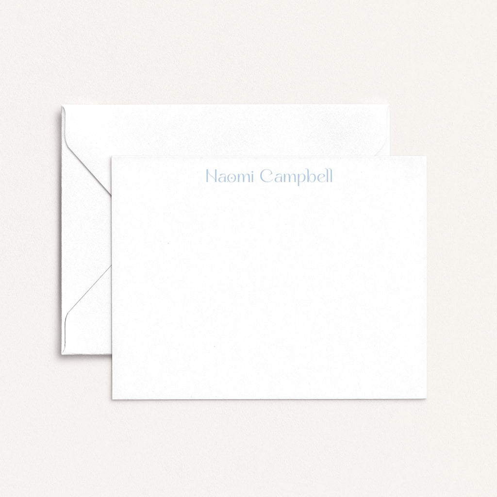Naomi personalized notecards by Blú Rose, white flat notecard with the name 'Naomi Campbell' in dusty blue, shown with a white envelope