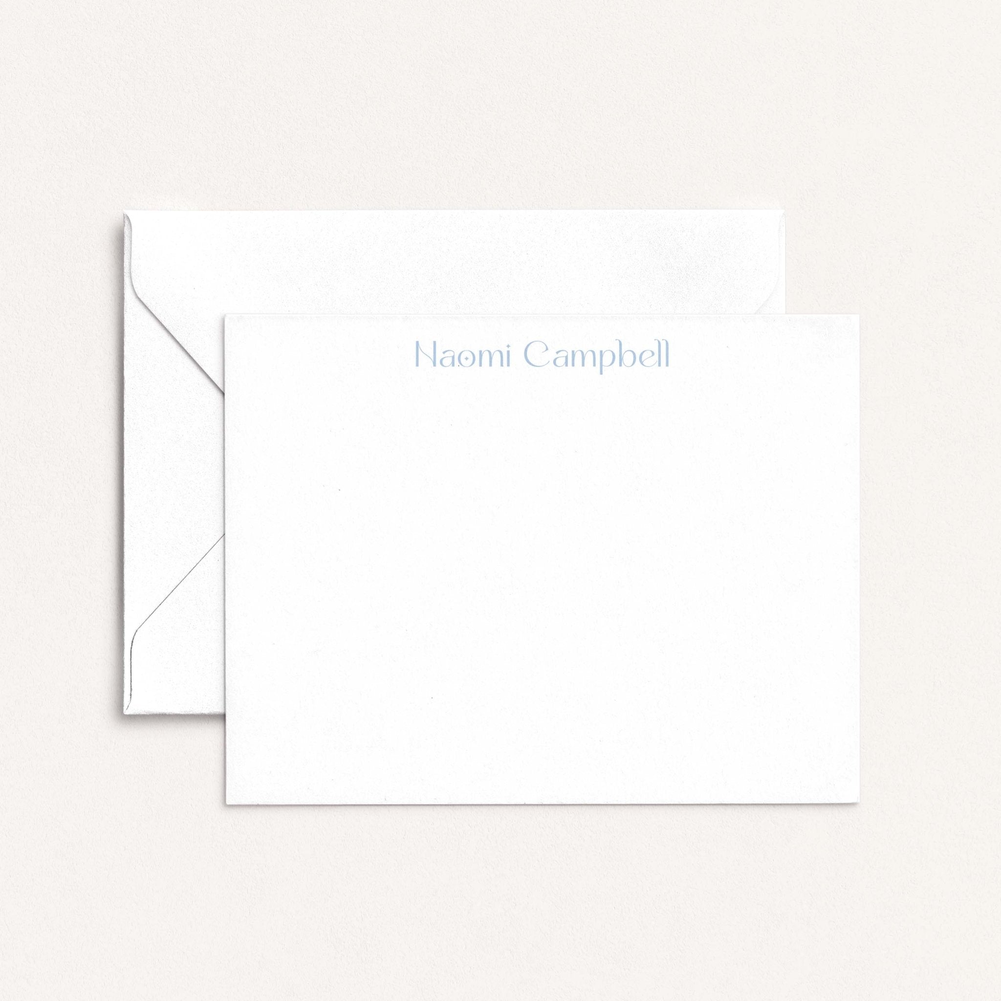 Naomi personalized notecards by Blú Rose, white flat notecard with the name 'Naomi Campbell' in dusty blue, shown with a white envelope