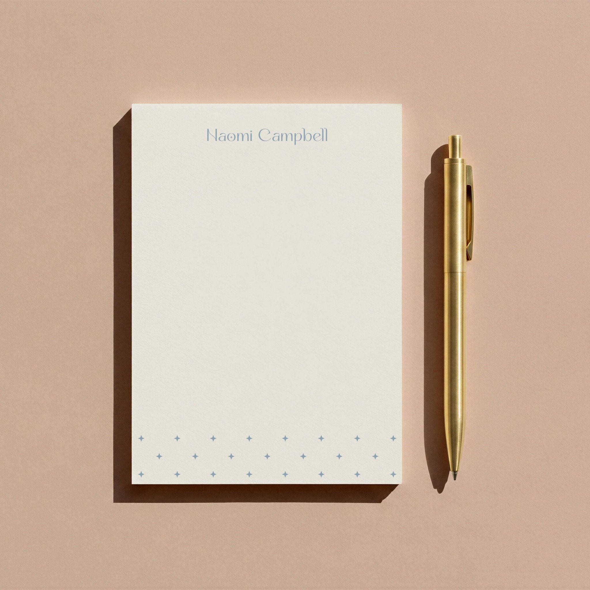 Naomi Star personalized notepad by Blú Rose, star-patterned notepad photographed with a gold pen on a mauve background