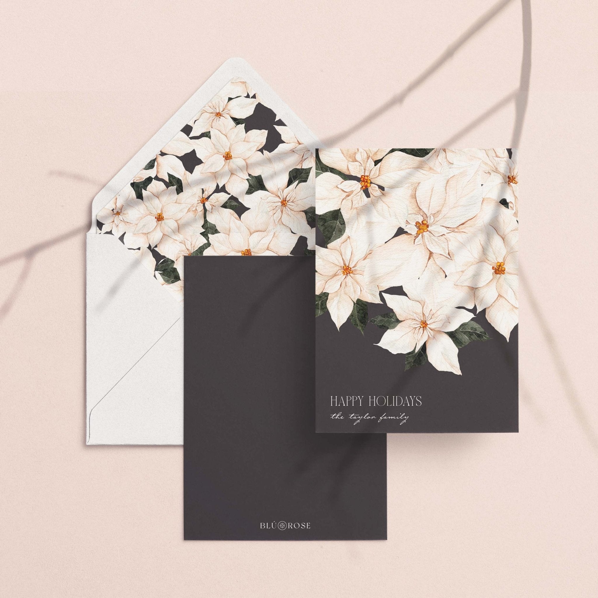 Perfect Poinsettia card with its white poinsettia envelope liner styled on a blush backdrop