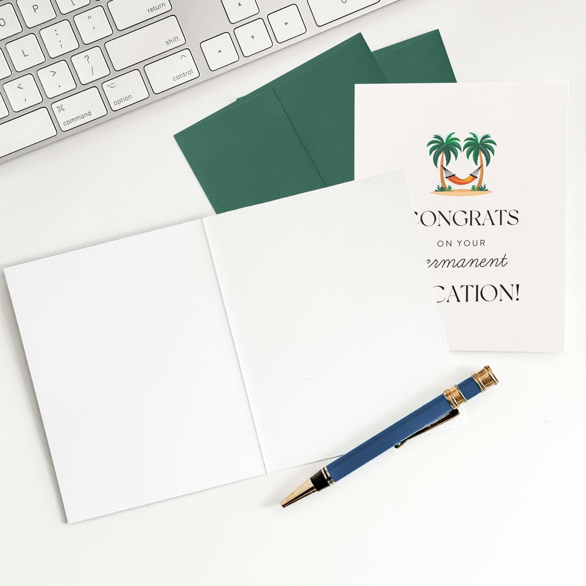 Permanent Vacation retirement card by Blú Rose shown open with blank interior, green envelope and pen on a white desk