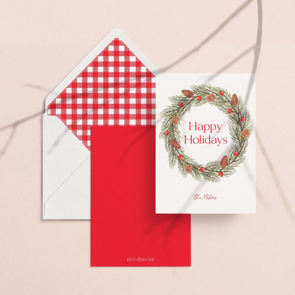 Pinecone Berry Wreath card with its red gingham envelope liner styled on a blush backdrop