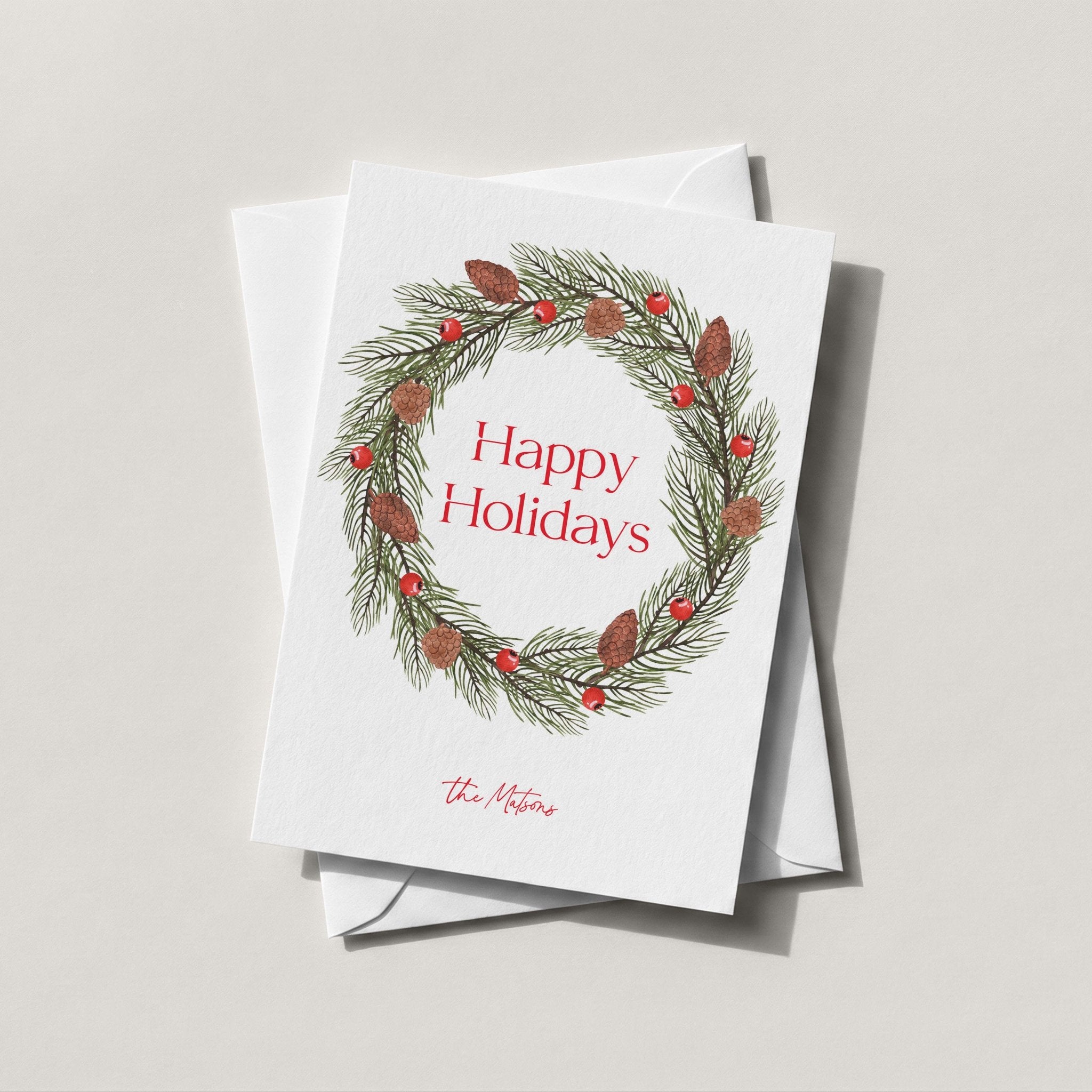 Pinecone Berry Wreath card with a red berry and pine wreath around Happy Holidays script
