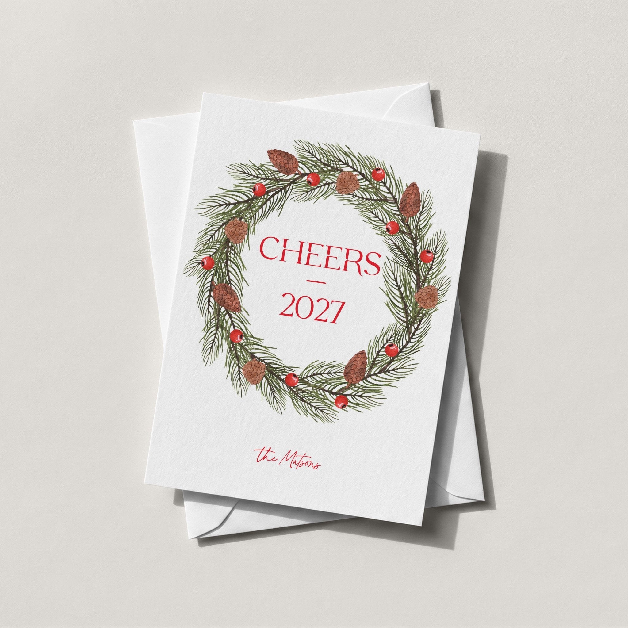 Pinecone Berry Wreath card in white with a red berry and pine wreath framing CHEERS 2027