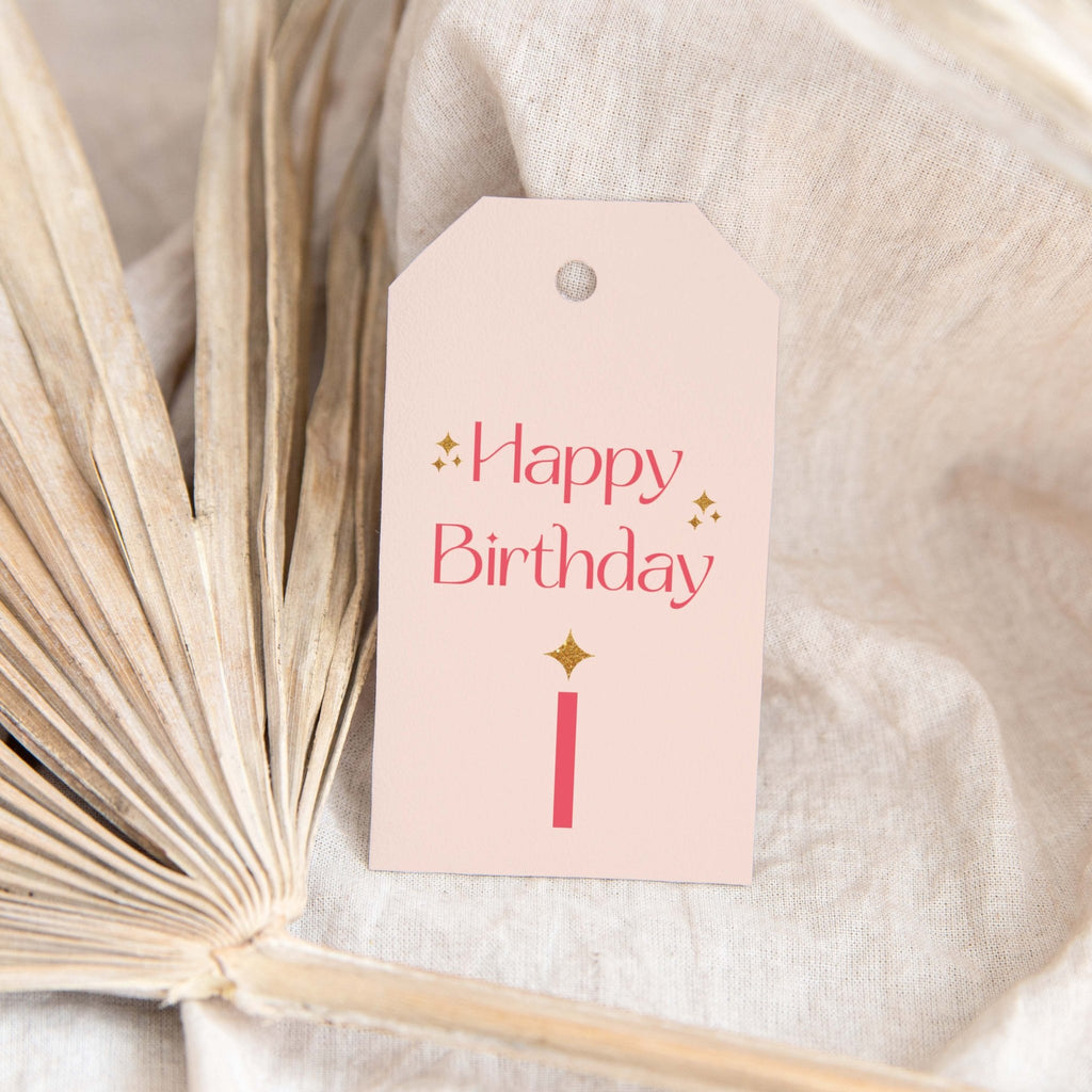 Pink Sparkle Birthday gift tags by Blú Rose, blush 'Happy Birthday' tag with pink lettering and a gold sparkle candle styled on a dried palm leaf