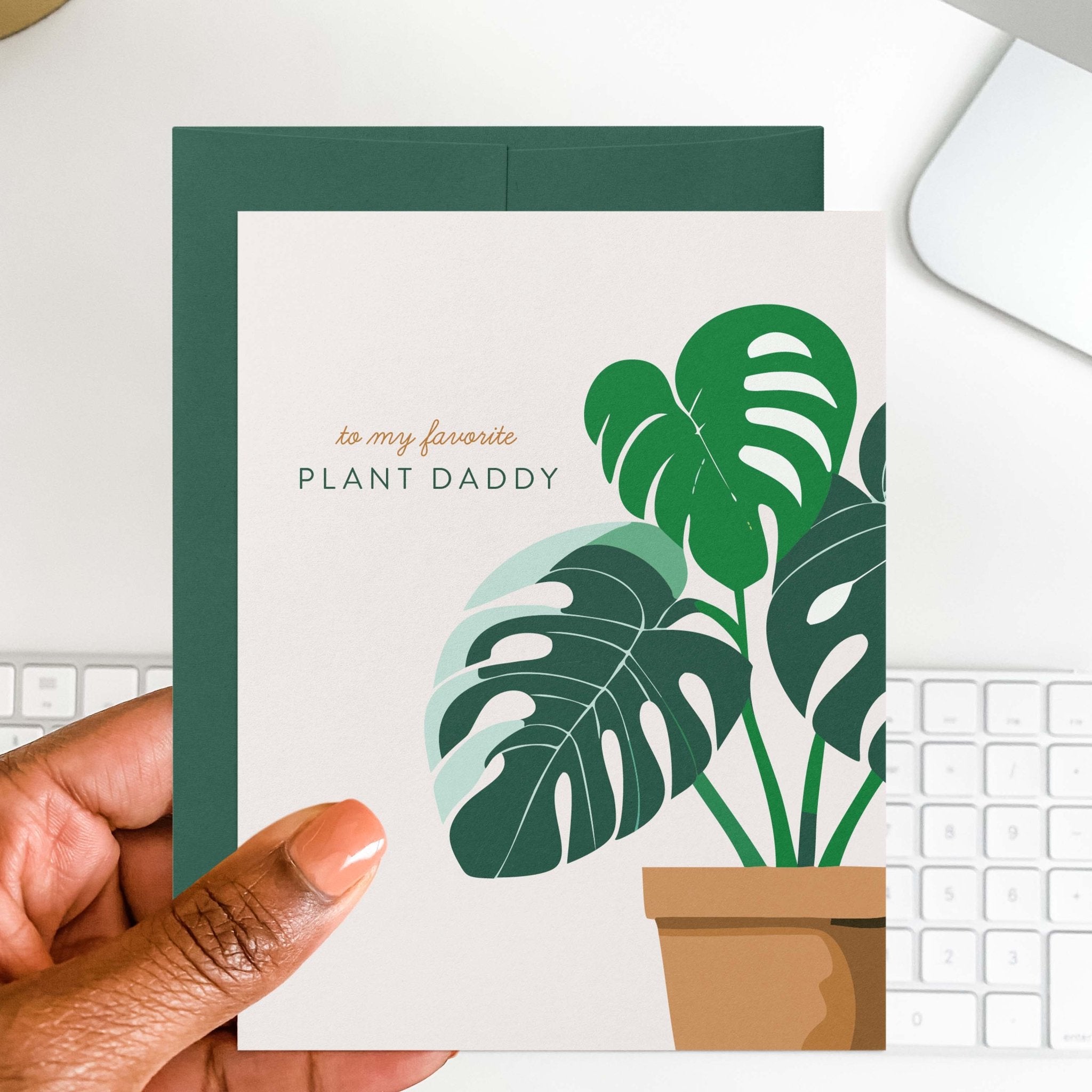 Plant Daddy Father's Day card by Blú Rose held in hand over a white desk with keyboard and green envelope