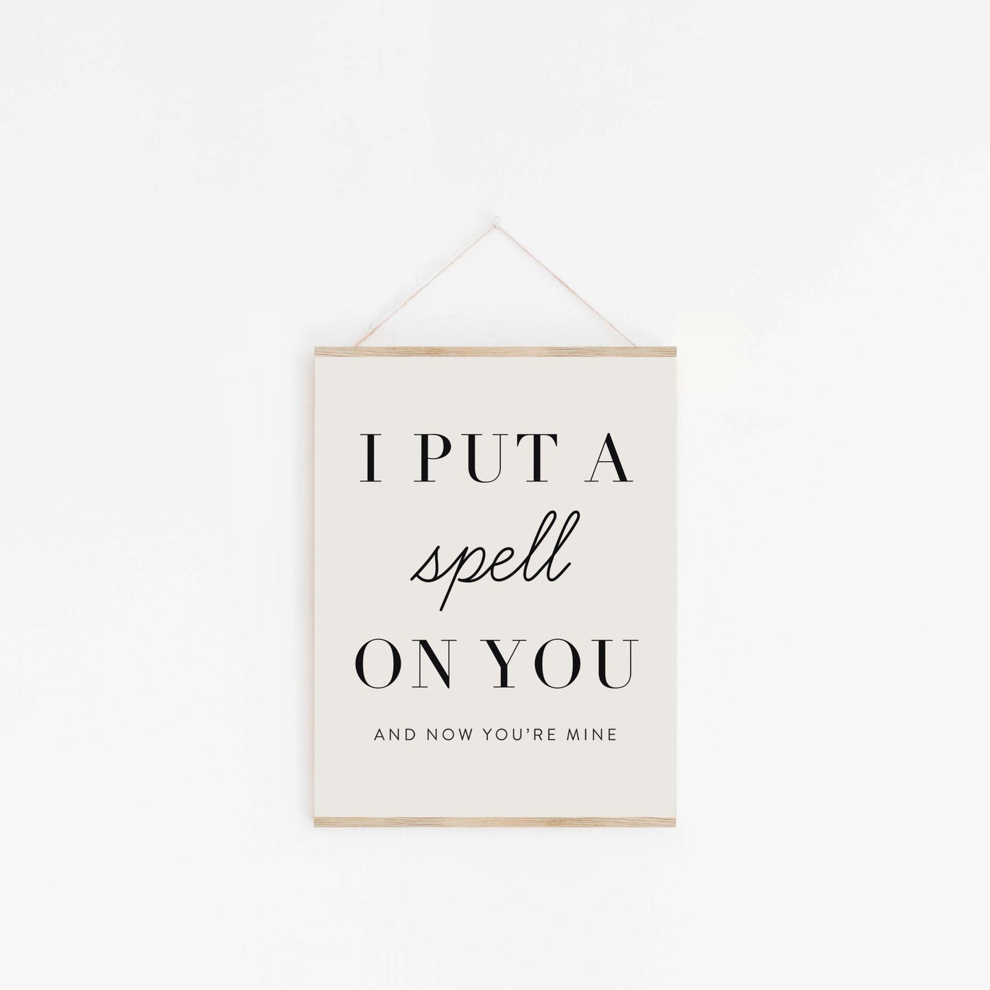 Put A Spell On You quote poster hanging from wood hanger with minimalist typography design