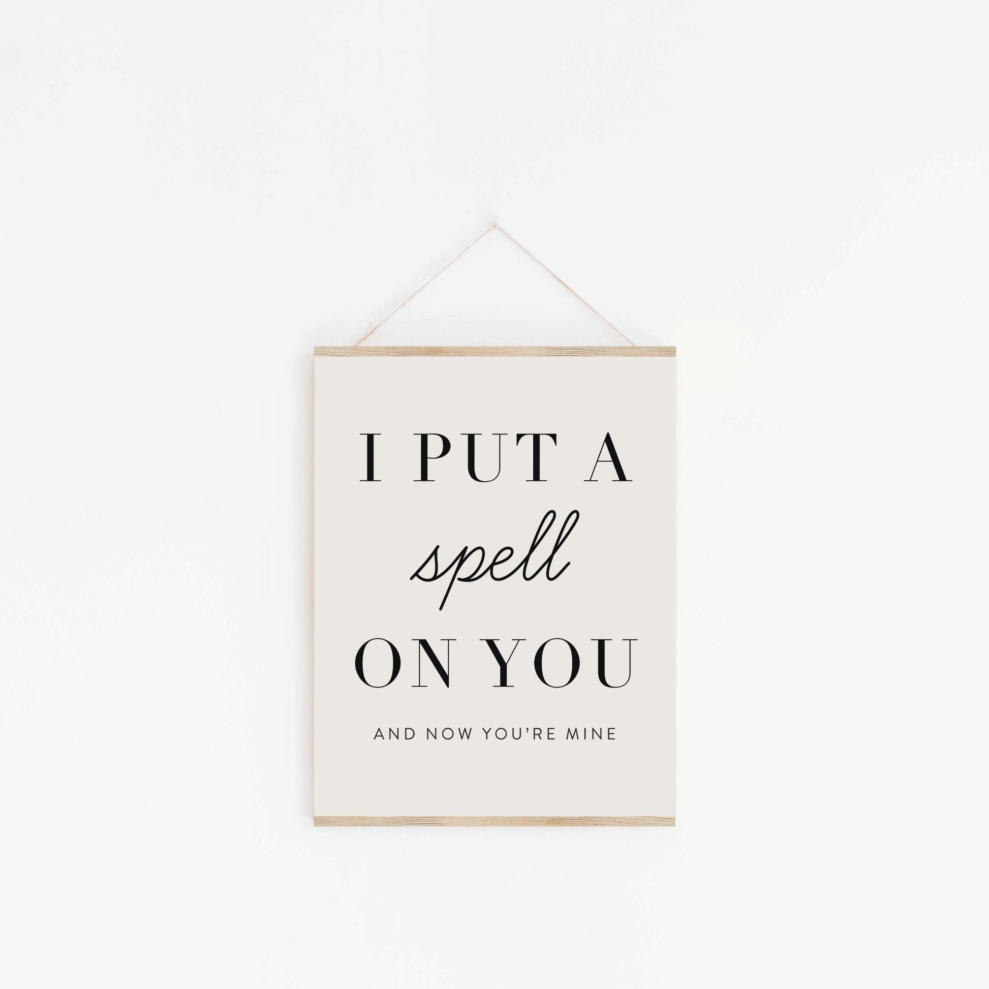 Put A Spell On You quote poster hanging from wood hanger with minimalist typography design
