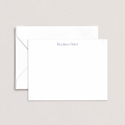 a white envelope and a blank white card with the name "Regina Grier" printed on it.