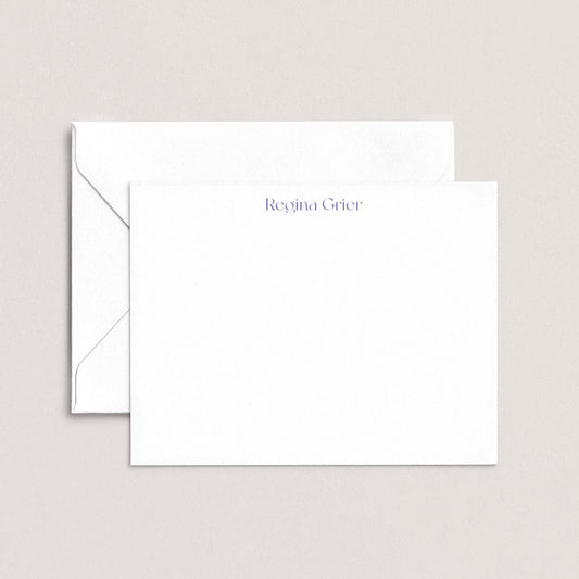 a white envelope and a blank white card with the name "Regina Grier" printed on it.