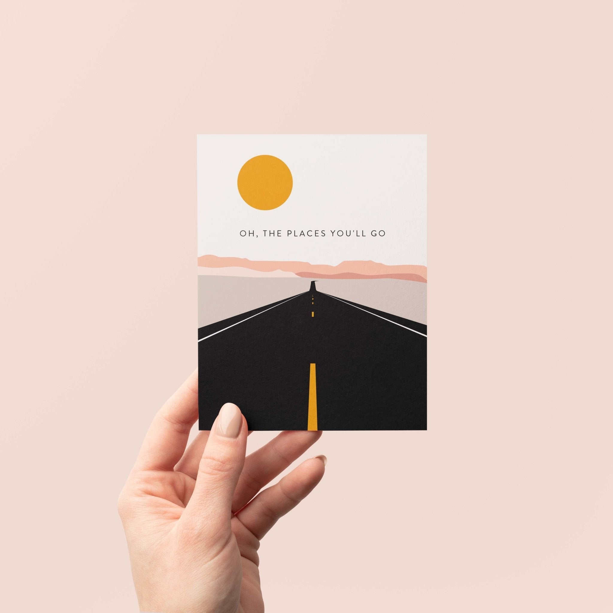 Road Trip graduation greeting card by Blú Rose held in hand against a neutral off-white background