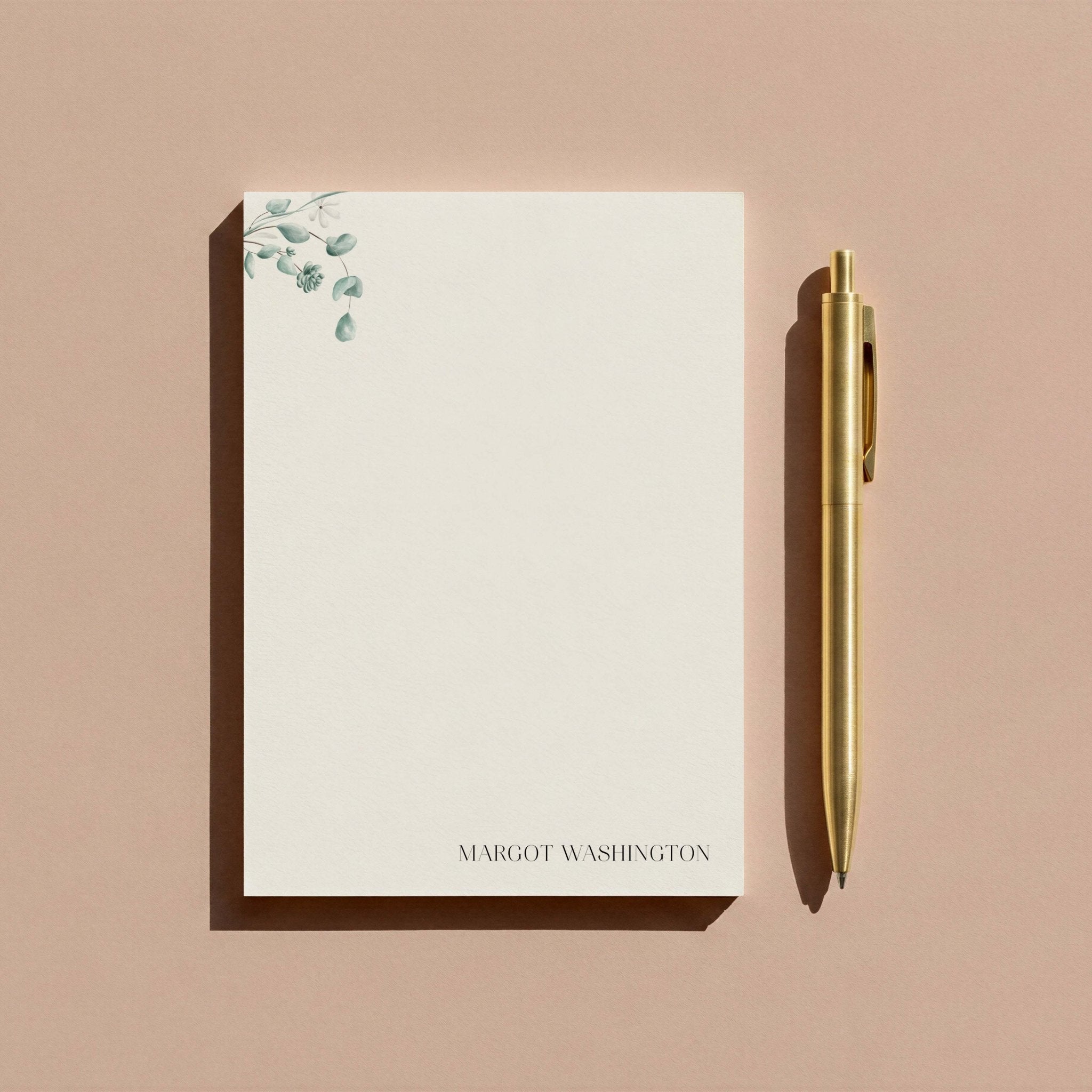 Simple Floral personalized notepad by Blú Rose, eucalyptus notepad photographed with a gold pen on a mauve background