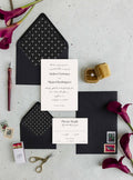 Simply Chic wedding invitation suite by Blú Rose, cream invitation and reply card with elegant script names, styled with geometric-lined black envelopes and deep red calla lilies
