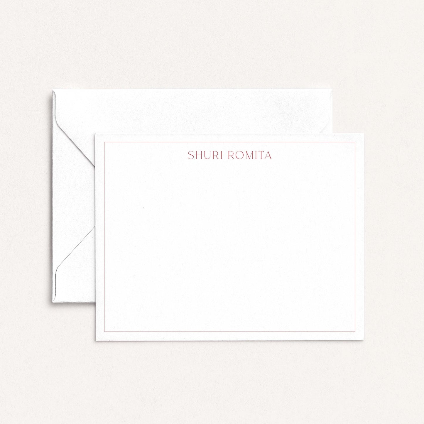 Personalized flat notecard with Ironroot red border and name in serif font, shown with matching envelope on neutral background.