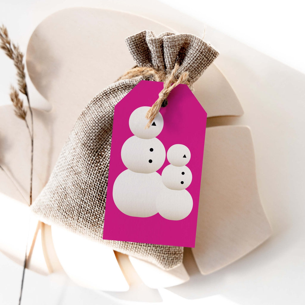 Snow People gift tag by Blú Rose, magenta tag with a white snow people family design on a burlap favor bag