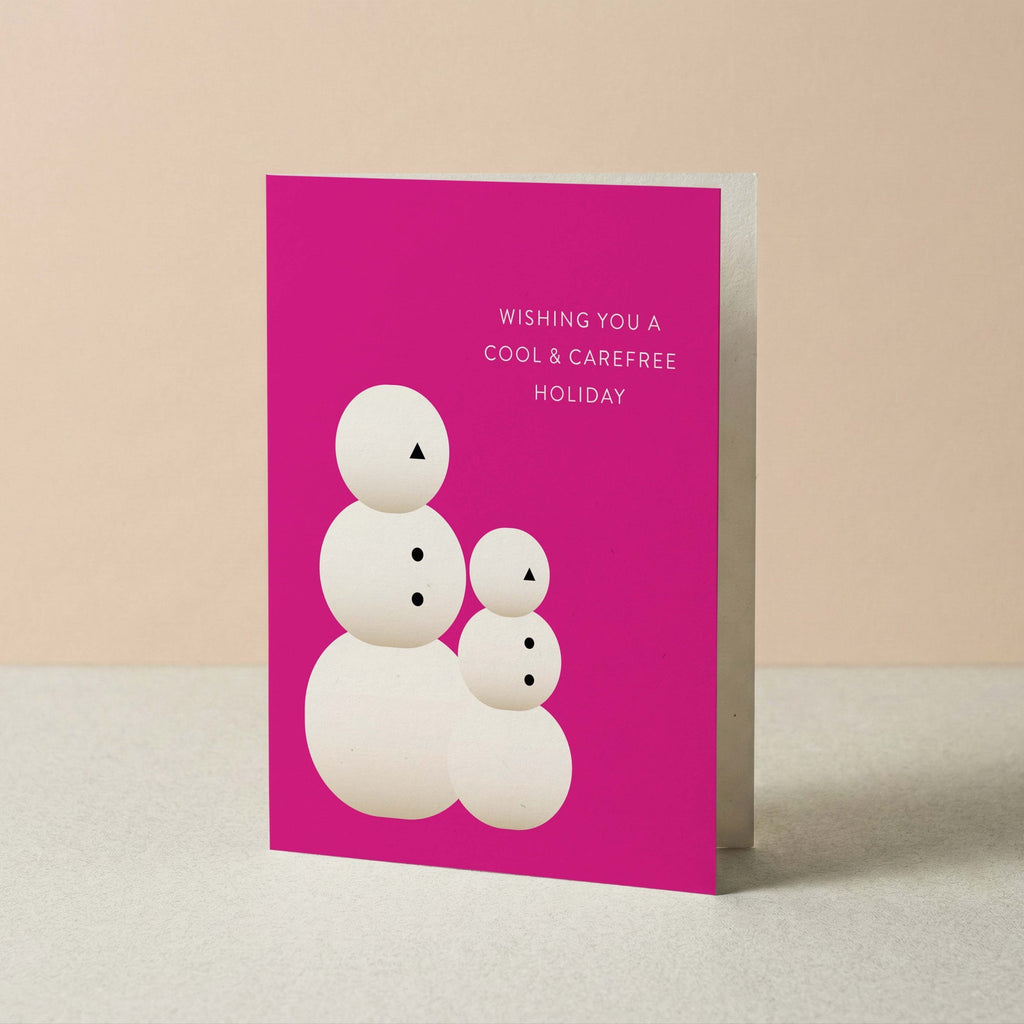 Snow People Christmas card by Blú Rose standing upright, magenta card with snow people illustration on a neutral background