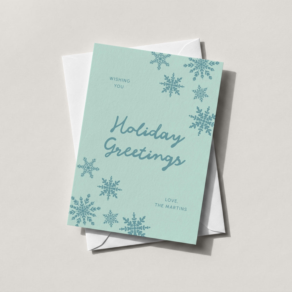 Snowflake Greetings card in soft teal with Holiday Greetings script and falling snowflakes