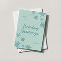 Snowflake Greetings card in soft teal with Holiday Greetings script and falling snowflakes