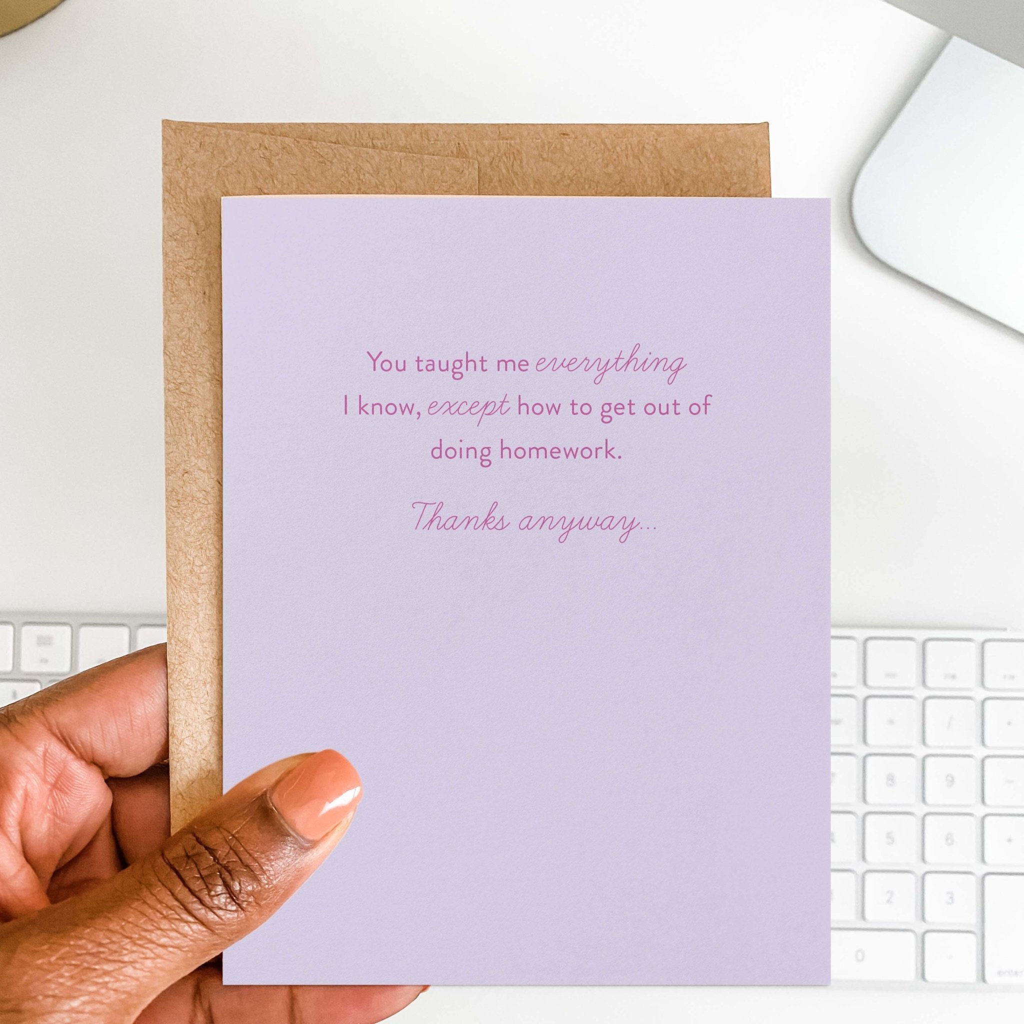 Taught Me Everything teacher greeting card by Blú Rose held in hand over a white desk with keyboard and kraft envelope