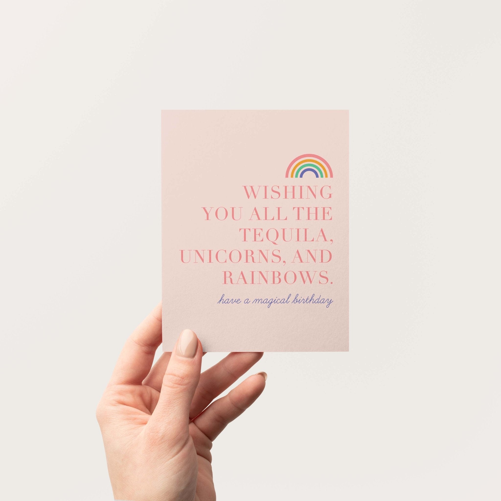 Tequila, Unicorns & Rainbows birthday card by Blú Rose held in hand against a neutral off-white background