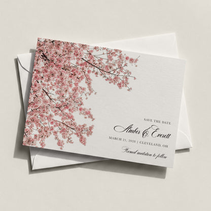 The Cherry Blossom Save the Date by Blú Rose featuring cascading pink cherry blossom branches with classic black script on white cardstock displayed on a white envelope