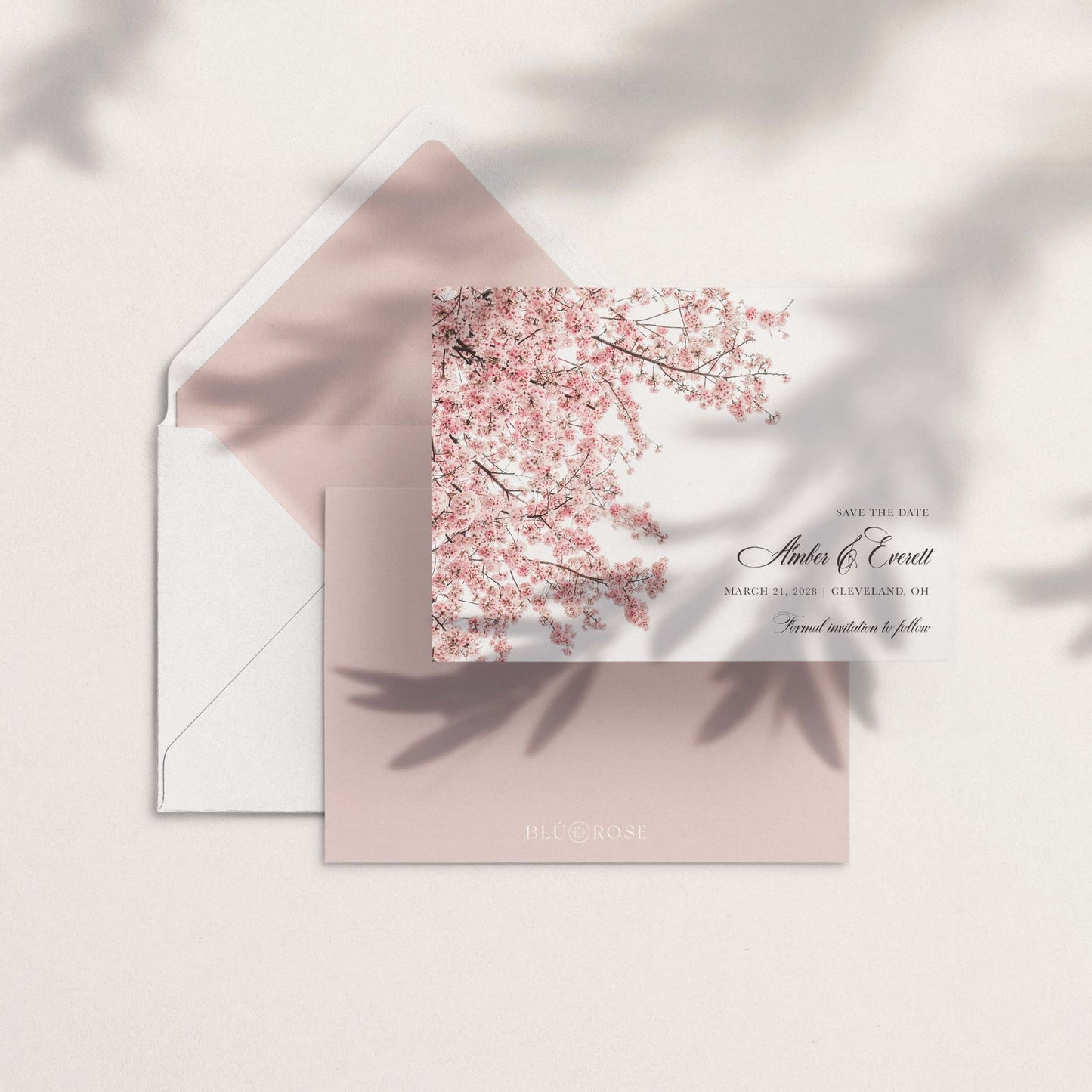 The Cherry Blossom Save the Date shown with pink envelope liner featuring cherry blossom branches with soft natural shadows