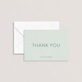 The Olivia personalized thank you card by Blú Rose in sage green with dark green text shown flat with white envelope on a neutral background