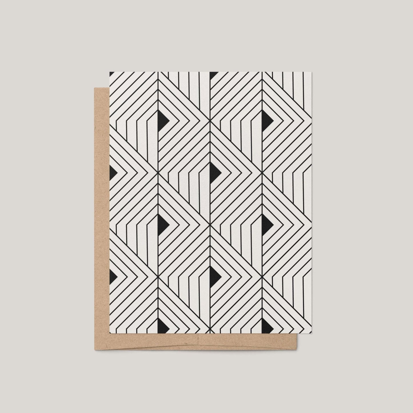 The Prism Greeting Card by Blú Rose featuring a bold black and off-white geometric angular pattern shown with a kraft envelope on a gray background