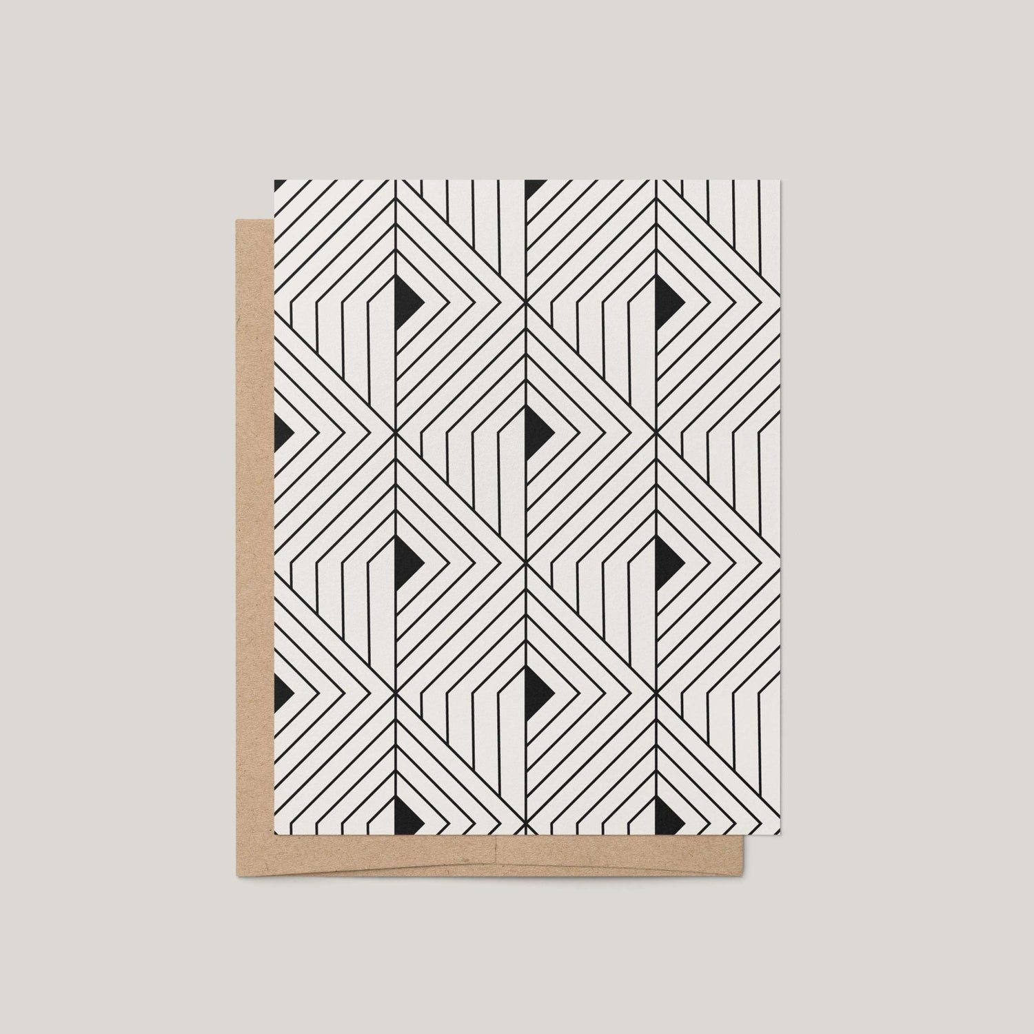 The Prism Greeting Card by Blú Rose featuring a bold black and off-white geometric angular pattern shown with a kraft envelope on a gray background