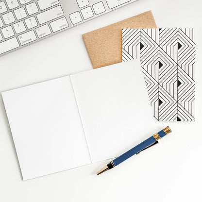 The Prism Greeting Card by Blú Rose shown open to reveal blank inside with pen on a white desk alongside kraft envelope