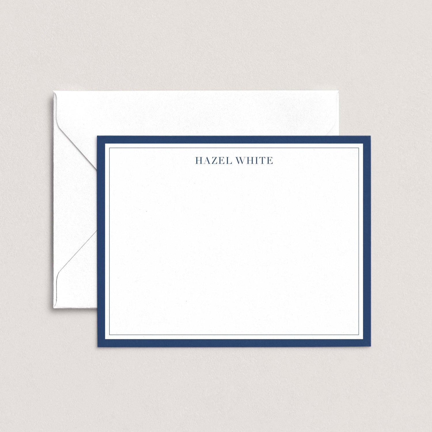 A white envelope with a blue border, and a blank white card with a blue border, both placed on a light background.
