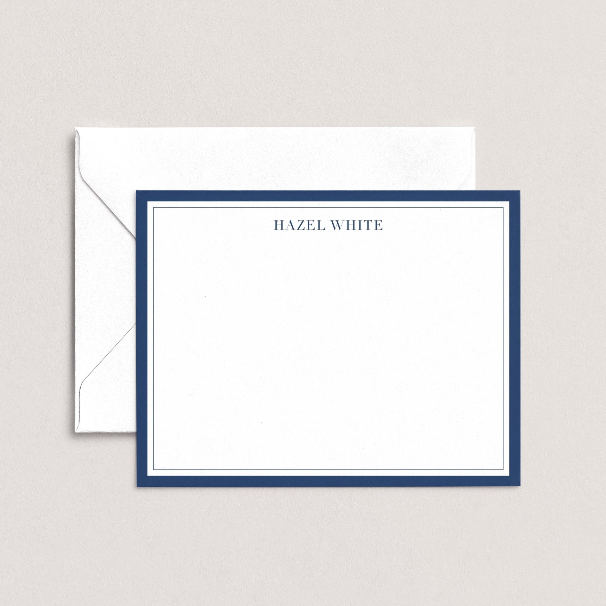 A white envelope with a blue border, and a blank white card with a blue border, both placed on a light background.