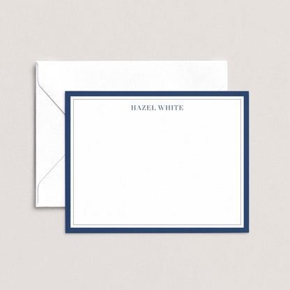 A white envelope with a blue border, and a blank white card with a blue border, both placed on a light background.
