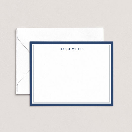 A white envelope with a blue border, and a blank white card with a blue border, both placed on a light background.