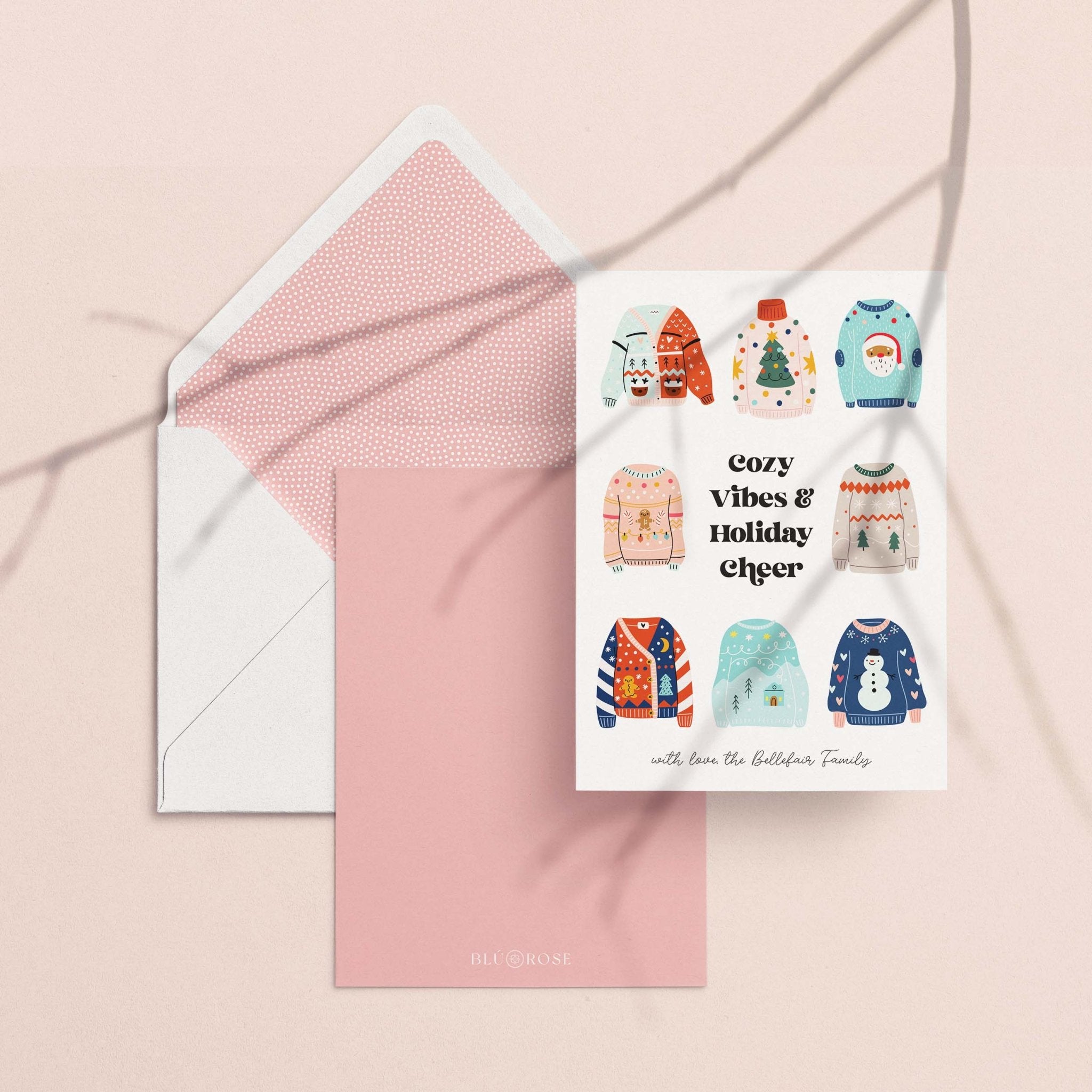 Ugly Sweater card with its dusty pink envelope liner styled on a blush backdrop