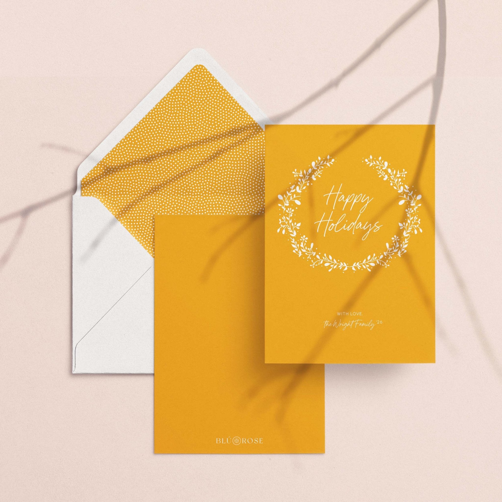 White Wreath card with its marigold envelope liner styled on a blush backdrop