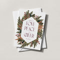 Winter Wreath holiday card with a pine and berry wreath framing LOVE PEACE CHEER in a diamond