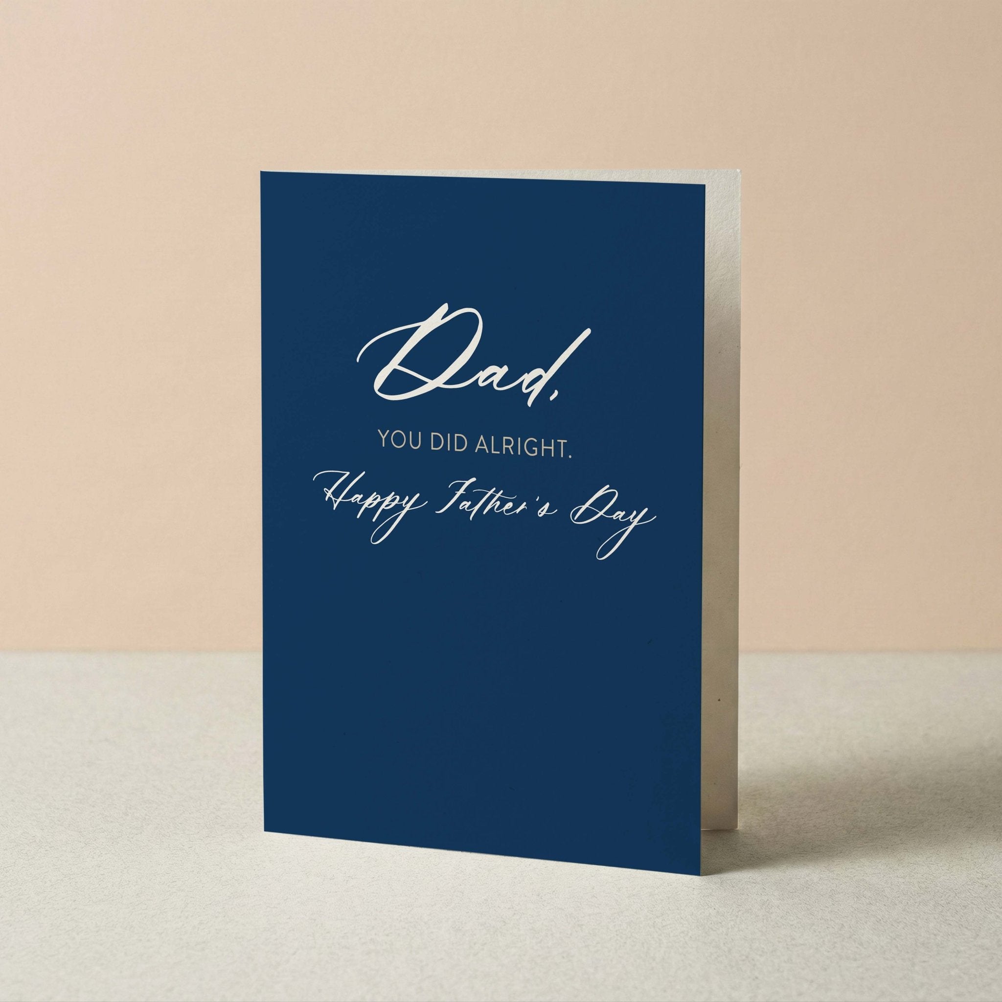 You Did Alright dad card by Blú Rose standing upright, navy card with white script on a neutral background