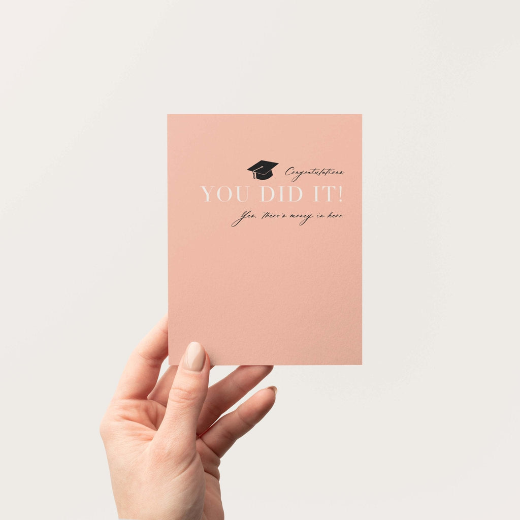 You Did It graduation money greeting card by Blú Rose held in hand against a neutral off-white background