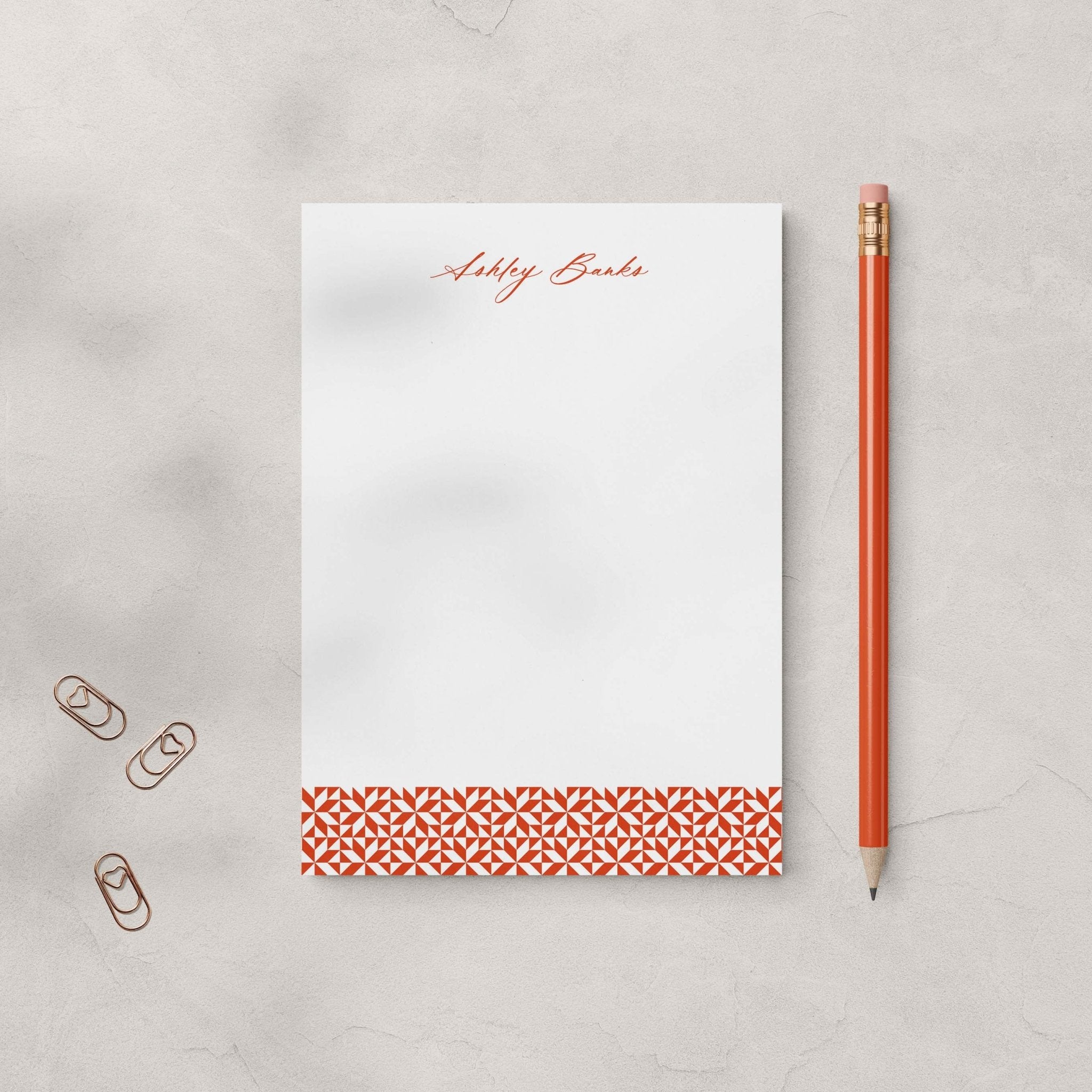 Ashley stationery set by Blú Rose, rust geometric-accent notepad personalized 'Ashley Banks', styled with a rust pencil and heart paper clips