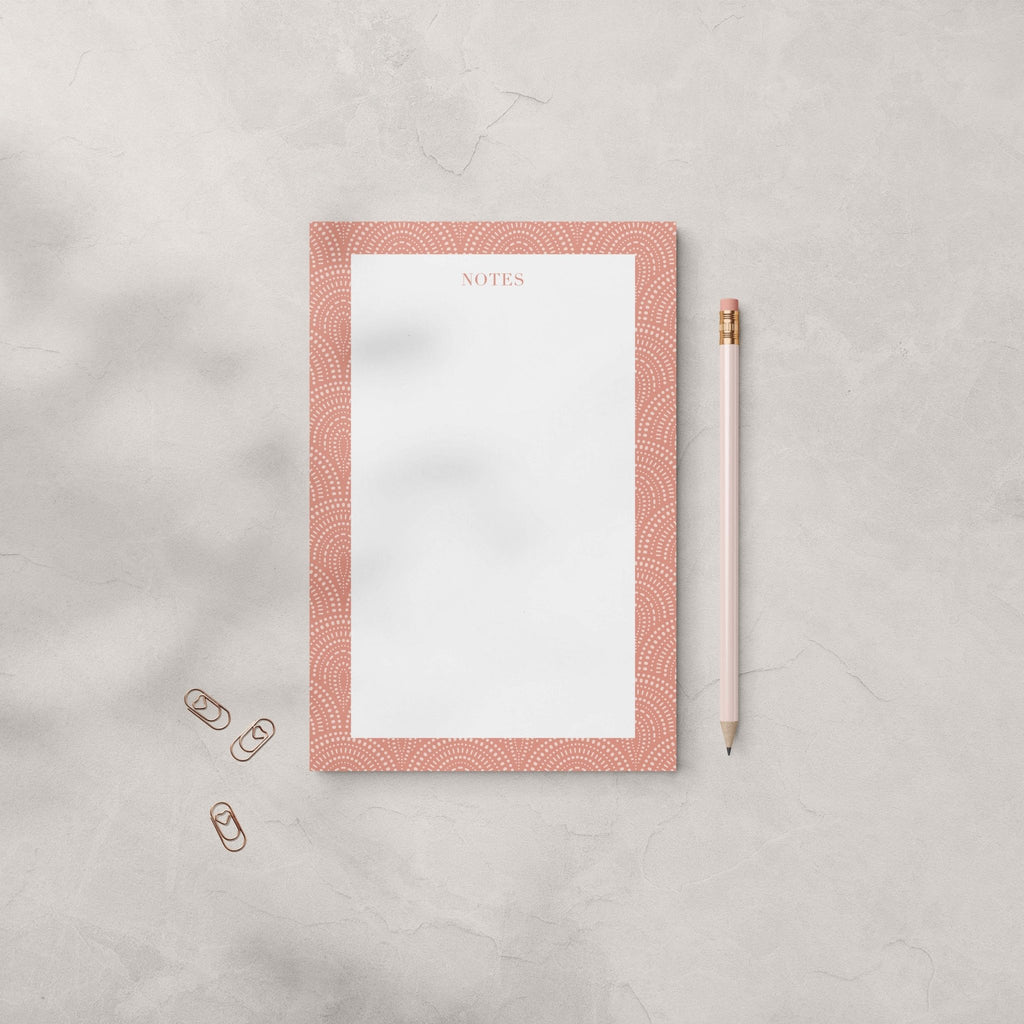Fancy Arches notepad by Blú Rose, terracotta arch-bordered notepad photographed with a pink pencil and heart paper clips on a gray surface