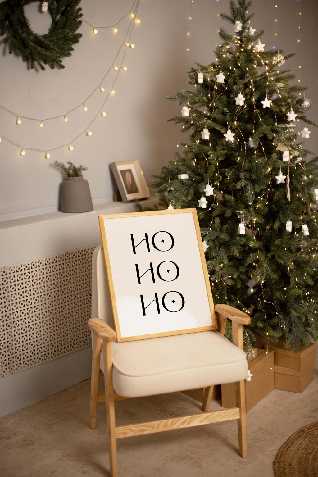 Ho Ho Ho Christmas wall art displayed on chair near holiday tree