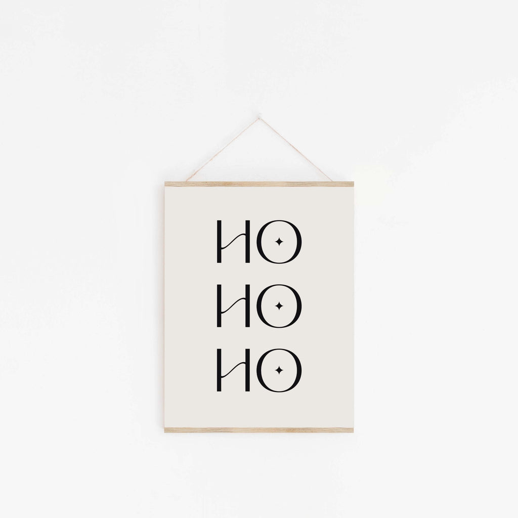 Minimalist Ho Ho Ho Christmas poster hanging from wooden hanger