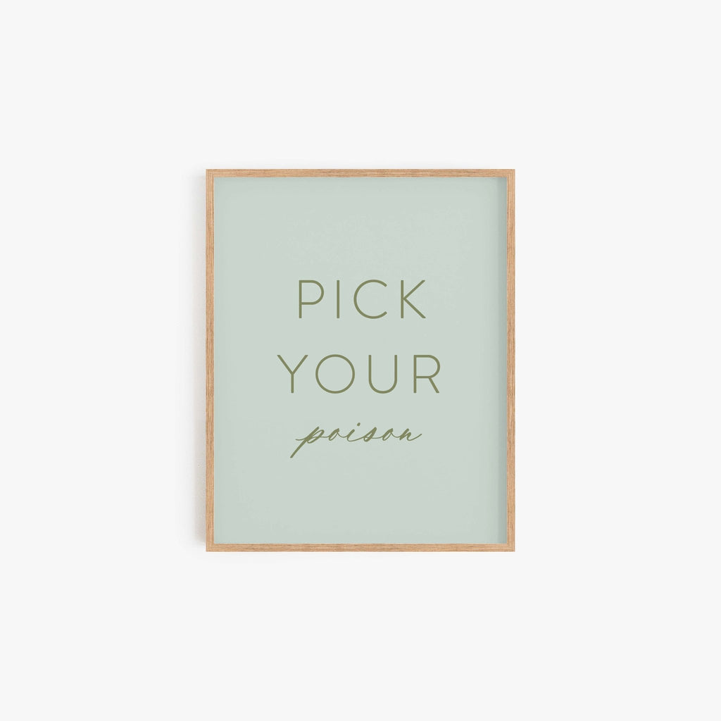 Pick Your Poison typography art print in sage green with minimalist lettering in light wood frame
